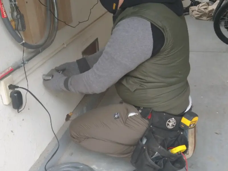 Electrician performing outlet wiring in a Cold Spring garage